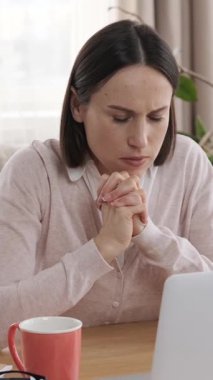 Mutlu ofis çalışanı laptopta çalışırken ya başarıyı ya da başarıyı kutluyor. Profesyonel bir ofiste başarılı olma anından zevk alıyor. Dikey video.