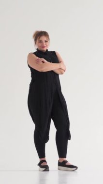 Gülümseyen ve neşeli bir kadının portresi beyaz arka planda kameraya bakıyor, pozitif insan konsepti. Dikey video.