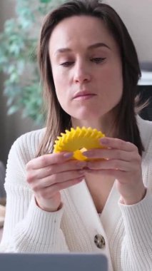 Evde plastik dişli ve 3D yazıcıda çalışan düşünceli beyaz kadın mühendis. Yerli imalat ve bilim laboratuarı kavramı.