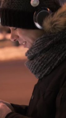 Adam dışarıda gezinirken akıllı telefonu internet keyfi için kullanıyor. Serbest zaman aktivitesi ve dijital eğlence konsepti. Dikey video.