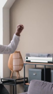 Orta Doğulu mutlu bir çift müzik eşliğinde dans ediyor ve evde eğleniyor. Yurt içi boş zaman kavramı. Dikey Video.