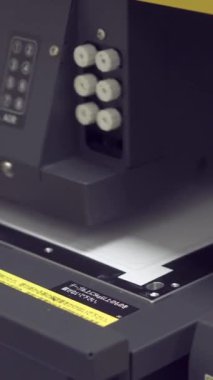 Modern UV yazıcısı aktif olarak bir fabrikada çalışıyor, gelişmiş iş ekipmanları ve makine mühendisliği sergiliyor. Dikey video.