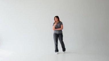 Mutsuz ve yorgun Kafkasyalı genç kadın can sıkıntısı çekiyor ve beyaz arka planda düşünüyor. Melankoli, belirsizlik, yalnızlık konsepti.