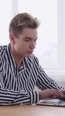 Ofisteki online iş muhasebe için dizüstü bilgisayar kullanıyor, finansal verileri yönetiyor ve odaklı raporlar üzerinde çalışıyor. Dikey video.