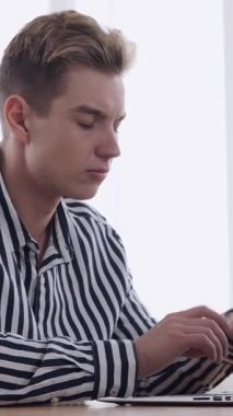 Ofiste iş görüşmelerini yürütürken telefona cevap veren adam profesyonel iletişim ve karar verme ile meşgul. Dikey video.