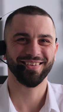 Ofiste çalışan mutlu ve gülümseyen orta yaşlı bir beyaz erkek çağrı merkezi ajanı ya da yardımcı masa çalışanı portresi. Dikey video.