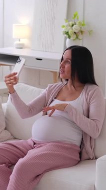 Mutlu Kafkasyalı orta yaşlı hamile kadın blogcu evde online sosyal medya için video kaydediyor. Seyircilerle iletişim kurma kavramı. Dikey video.