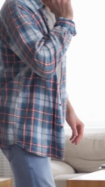 Freelancer evde çalışırken telefonda bir iş görüşmesi yapıyor. Aramalarla ve iletişimle meşgul. Dikey video.