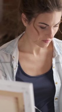 Nişanlı bir kadın sanat terapisi yapıyor, atölyede resim yapıyor. Sanat eserleri yaratmak için yaratıcı ve düşünceli bir sanatsal süreç. Dikey video.