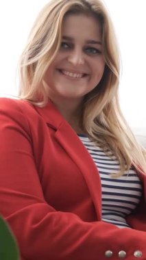 Ofiste çalışan başarılı bir kadının portresi. Pozitif iş adamı ya da yönetici, idari liderlik ve kendine güvenen bir ifadeyle profesyonellik. Dikey video.