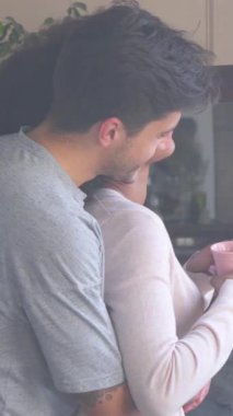 Kız arkadaş ve erkek arkadaş sabah rutininde kucaklaşıyorlar. Hoş karşılama ve soğuk bir çevrede beraberlik ve memnuniyet. Dikey video.