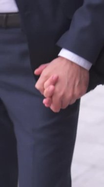 Romantik bir açık hava randevusu sırasında el ele tutuşan bir çiftin yakın çekimi. İmaj aşkı, bağı ve yakınlığı yakalar. Çiftin birlikte geçirdiği zamanın tadını çıkarır. Dikey video.