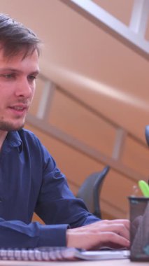 Pozitif ofis çalışanı, hafta sonu için hazır olarak iş gününün sonunda ofisten çıkıyor. Rahatlama, memnuniyet ve iş hayatı dengesi. Dikey video.