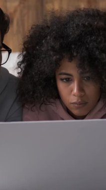 Dost canlısı çift dizüstü bilgisayarla çevrimiçi iletişimi sürdürürken evde zaman geçirmeyi seviyor. Rahat kurulum modern dijital birlikteliği gösteriyor. Dikey video.