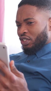 Dost canlısı Afrikalı Amerikalı bir adam online video görüşmesi ve evdeki uzaktan konuşma için bir tablet bilgisayar kullanıyor. İletişim, teknoloji ve bağlantı. Dikey video.