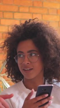 Neşeli eş ve koca evde vakit geçirmeyi, internet üzerinden neşeli bir şekilde iletişim kurmayı ve çeşitli aktiviteler için telefon kullanmayı seviyorlar. Dikey video.