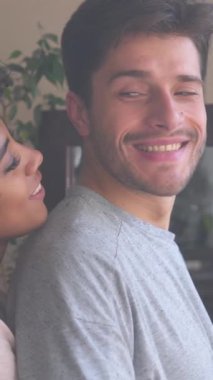 Gülümseyen bir çift yatak odasında kucaklaşmaktan zevk alıyor. Şefkat ve şefkat, rahat bir ortamda şehvetli ilişkiyi tanımlar. Dikey video.