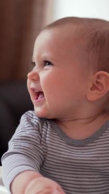 Yavru bebek, evdeki mutfakta şefkatli annesiyle yemek yiyor, çocukluk ve çocukluk anılarını yakalıyor. Dikey video.