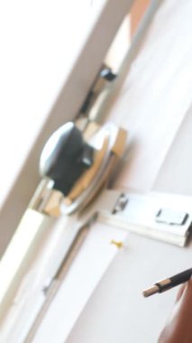 Konsantre terzi bir atölyede çalışıp ilham ve sanat eserlerine odaklanarak desenler ya da eskizler yaratır. Ayrıntılara bağlılık ve dikkat. Dikey video.