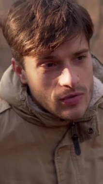 Karı ve koca, ormanda birlikte sessiz sakin sohbet ederken ve dışarıda dinlenirken boş vakitlerin tadını çıkarıyorlar. Dikey video.