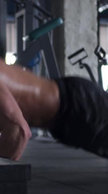 Spor yaparken şınav çeken terli bir adam. Dayanıklılık, performans ve fiziksel eğitimin yoğunluğu. Dikey video.