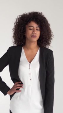 Rahatsız ve sıkılmış Afro-Amerikan çalışanı beyaz bir geçmişi olan birini beklerken kol saatini izliyor. Dikey video.