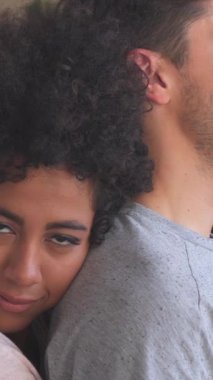 Neşeli kadın ve erkek evde kucaklaşıyorlar. Sevgi ve mutluluk, sıcaklık ve neşe dolu rahat bir atmosferde tutkuyla harmanlanır. Dikey video.