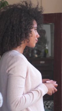 Adam kadını battaniyeye sarıp evinde kucaklıyor. Romantizm ve tutku samimi ve sıcak bir ortamda mutlu bir an yaratır. Dikey video.