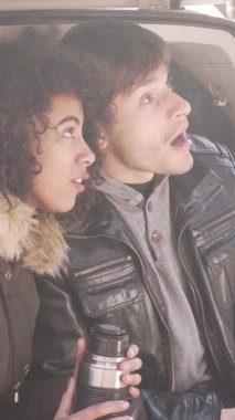 Mutlu kız arkadaş ve erkek arkadaş boş zamanlarında birlikte dinleniyor, huzurlu bir ortamda çay içerken birbirlerine eşlik ediyorlar. Dikey video.