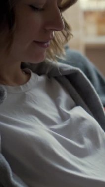 Hamile bir kadının evde bebek okşamaları yapması, ilgiyi, heyecanı ve gelecekteki ebeveynlik beklentisini yansıtıyor. Dikey video.