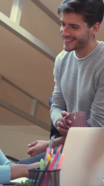 Ofiste birlikte çalışan pozitif iş arkadaşları, bir projeyi analiz ediyorlar ve iş geliştirme konusunu tartışıyorlar, sohbete dalıyorlar. Dikey video.