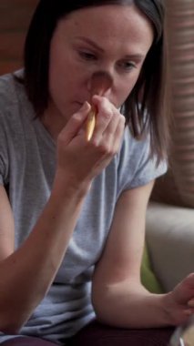 Evde fırça kullanarak makyaj yapan mutlu bir kadın sabah güzellik rutininin ve doğal güzelliğin tadını çıkarıyor. Dikey video.