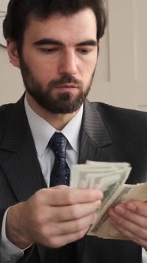 Ofiste nakit para sayan, bütçeye, servete ve finansmana odaklanan, profesyonel bir ortamda iş kaynaklarını düzenleyen özenli bir çalışan. Dikey video.