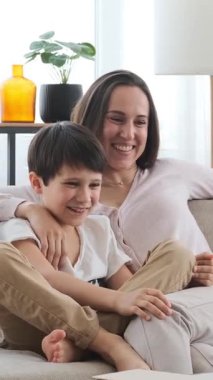 Memnuniyet duyulan oğul ve anne evde eğlenirken rahat bir ortamda rahatlatıcı bir anı paylaşıyorlar. Dikey video.