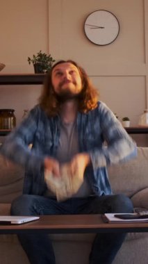 Memlekette para yağmuru yaratmak için para saçan olumlu bir adam, şevkle ve coşkuyla zenginliği ve refahı kutluyor. Dikey video.