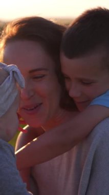 Çocuklarla birlikte anne boş zamanlarında dışarıda gezer, doğada tatmin ve eğlence arar, huzurlu bir ortamda neşeli anlar yaratır. Dikey video.