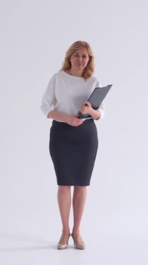 Beyaz bir arkaplanda bir portrede tatmin olmuş ve neşeli bir iş adamı ya da öğretmen, özgüvenli bir ifadeyle bireysellik ve zarafet sergiliyor. Dikey video.