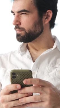 Düşünceli bir adam internette geziniyor ve evdeki akıllı telefonu kullanarak sosyal medyada mesajlaşıyor, rahat bir dijital ortamda düşünceli bir ağ iletişimi kuruyor. Dikey video.