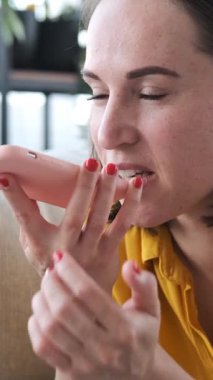 Evde boş zamanlarında sesli mesaj kaydetmek için cep telefonu kullanan bir kadın, rahat bir ortamda dijital bağlantıları korumak için odak noktasıyla mesajlaşıyor. Dikey video.