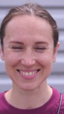 Beyaz, orta yaşlı, gülümseyen ve halinden memnun bir kadının açık havada kendine güveni ve bireyselliği gösteren portresi. Dikey video.