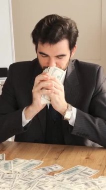 Bir ofise para saçan, milyoner olarak geliri ve sermayeyi kutlayan neşeli bir serbest yazar, canlı bir profesyonel çalışma alanında başarıyı ifade ediyor. Dikey video.