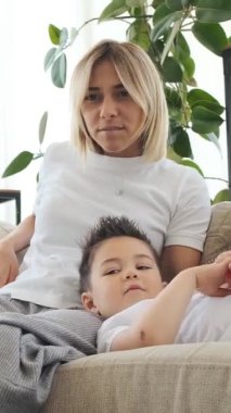 Oğul ve anne kucaklaşıp sohbet ediyorlar ya da evlerinde dedikodu yapıyorlar, dostluk kuruyorlar ve samimi bir mekanda paylaşılan anlar aracılığıyla iletişim kuruyorlar. Dikey video.