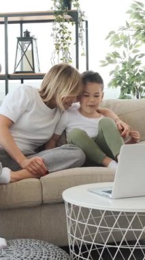 Evde boş zamanlarında dizüstü bilgisayar kullanarak, rahat ve bağlı bir ortamda ortak eğlencenin tadını çıkarıyorlar. Dikey video.