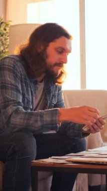 Akşamları evde para sayan, finans, refah ve tasarrufları yöneten, sakin bir ortamda zenginliği hassasiyetle idare eden bir adam. Dikey video.