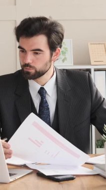 Ofisteki muhasebe işlerini yürüten, girişimleri ve yatırımları planlayan, kapalı alanlarda stratejik finansal görevlere girişen düşünceli bir serbest çalışan. Dikey video.