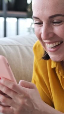 Gülümseyen kadın evdeki sosyal medya iletişimi için anlamlı ve neşeli dijital etkileşimle bir sesli mesaj kaydediyor. Dikey video.