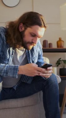 Hayal kırıklığına uğramış bir adam akşamları evde telefonla internette geziniyor, tanıdık bir yerde dijital keşiflerle uğraşırken can sıkıntısıyla boğuşuyor. Dikey video.