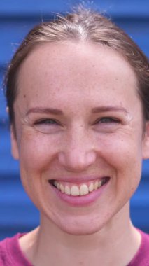 Kameraya bakan neşeli ve keyifli bir kadının portresi, açık hava aktiviteleri sırasında eşsiz bir kişiliği zevkle gösteriyor. Dikey video.