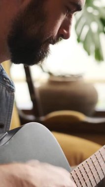 Gitarist, gitarist, ya da evde gitar çalan müzisyen, müzikte tatmin ve eğlence bulan, rahat ve rahat bir ortamda yeteneğini sergileyen. Dikey video.