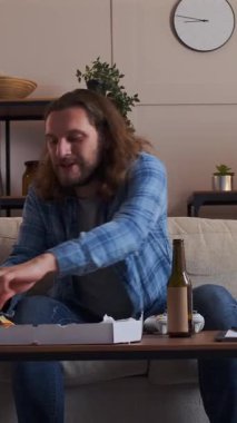 Akşamları evde boş vakitlerinde oyun sahası ile oyun oynayan konsantre bir adam dinleniyor ve odaklanmış bir dijital eğlence seansına katılıyor. Dikey video.